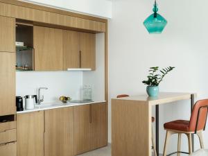 a kitchen with wooden cabinets and a table at The Chedi Luštica Bay in Tivat