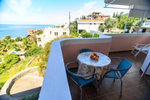 a table and chairs on a balcony with a view of the ocean at Villa Beba in Dobra Voda