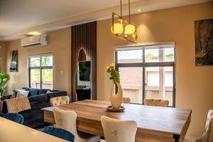 un salon avec une table et un canapé dans l'établissement The Luxe Escape Luxury Suite, à Stanmore Grove