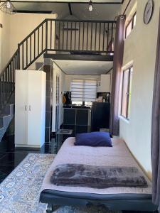 a large bed in a room with a staircase at Abe cottage in Kampung Kuala Besut