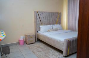 a small bedroom with a bed with ainding sqor at Greatwall Apartments Block D in Athi River +13 photos