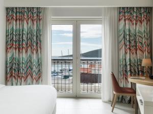 a bedroom with a large window with a view of the ocean at The Chedi Luštica Bay in Tivat