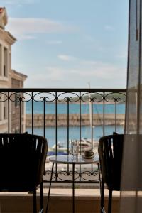 a table and chairs on a balcony with a view of the ocean at The Chedi Luštica Bay in Tivat