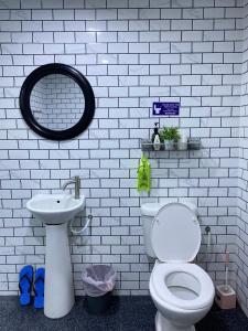 a white bathroom with a toilet and a sink at Abe cottage in Kampung Kuala Besut +8 photos