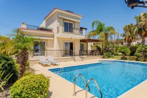 a villa with a swimming pool and a house at H&O Villa Arizona Gold Residence in Peyia