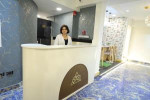 a woman standing behind a counter in a room at Gold Palace Hotel in Cairo