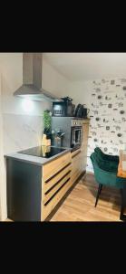 a kitchen with a stove and a green chair at FeWo - Heinsberg-Dremmen in Heinsberg