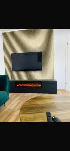 a living room with a fireplace with a television above it at FeWo - Heinsberg-Dremmen in Heinsberg