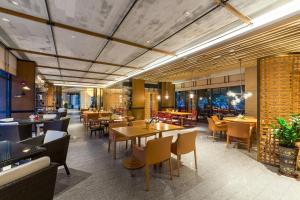 una sala da pranzo con tavoli e sedie e un ristorante di Lingshui Xiangshui Bay Summer Surfing Resort a Lingshui