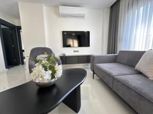 a living room with a couch and a table with flowers on it at Sweet Apartment in Side