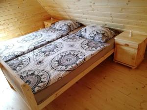 a bed in a cabin with a wooden floor at Chatka vo Vysokých Tatrách in Tatranska Strba
