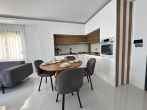 a kitchen and dining room with a wooden table and chairs at Sweet Apartment in Side