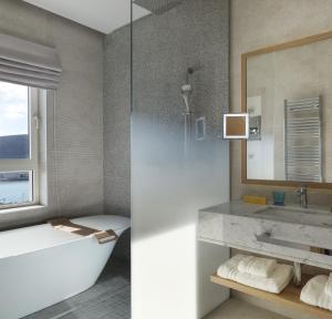 a bathroom with a tub and a sink and a mirror at The Chedi Luštica Bay in Tivat