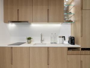a kitchen with a sink and wooden cabinets at The Chedi Luštica Bay in Tivat