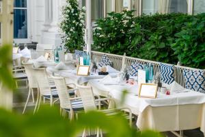 a row of tables with white tablecloths and chairs at Hotel Atlantic Hamburg, Autograph Collection in Hamburg