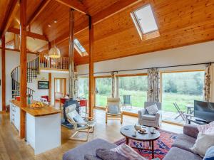ein großes Wohnzimmer mit Holzdecken und Fenstern in der Unterkunft 4 Bed in Fort William 78875 in Torcastle