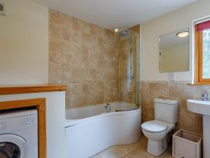 ein Badezimmer mit Badewanne, Toilette und Waschbecken in der Unterkunft 4 Bed in Fort William 78875 in Torcastle + 20 Fotos