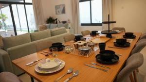 a wooden table with plates and utensils on it at Marina & Mountain View 4BR Private Villa in Fujairah