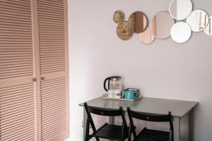 a dining room table with two chairs and mirrors on the wall at Sunny Homestay Room, 10 Mins North Laine, 6 Mins Station in Brighton & Hove