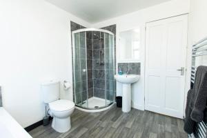 a bathroom with a toilet and a shower and a sink at K Suites - Granville Avenue in Long Eaton