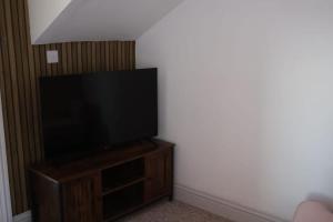a flat screen tv sitting on top of a wooden entertainment center at Filey in Moffat