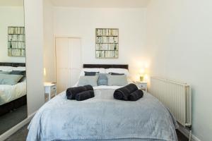 a bedroom with a large bed with three pillows on it at K Suites - Granville Avenue in Long Eaton