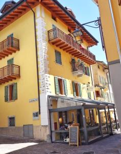 a yellow building with a sign in front of it at Appartamento Casaliva in Pieve Di Ledro