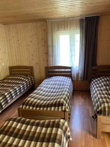 a bedroom with two beds and a window at Shatili ( Green House ) in Shatili +8 photos