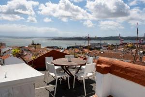 a table and chairs on a balcony with a view at Olympo Shared flat with Amazing River view in Lisbon