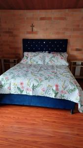 a bedroom with a bed with a floral bedspread at Casa Paipa in Paipa