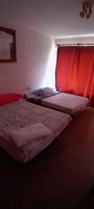 two beds in a bedroom with a red curtain at Cryptocalp in Calpe