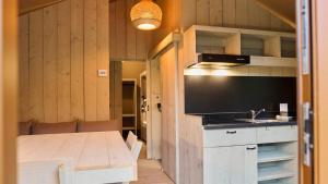 eine Küche mit einem Tisch und einem Großbild-TV in der Unterkunft moderne Glampingzelte in Winterberg