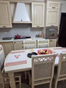 a kitchen with a table with a bowl of fruit on it at Karl Thopia Apartments in Durrës +11 photos