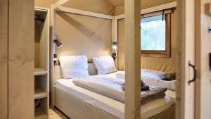 ein Bett in einem Zimmer mit Fenster in der Unterkunft moderne Glampingzelte in Winterberg