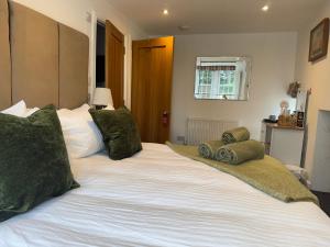 a large white bed with green pillows on it at Altonhill Cottage - room only in Nairn