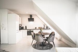 a kitchen and dining room with a table and chairs at Design trifft Komfort stilvolles Premium Apartment nahe St Leon Rot See in Sankt Leon-Rot