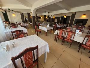 an empty restaurant with white tables and red chairs at Bartpol Family & SPA in Gródek Nad Dunajcem