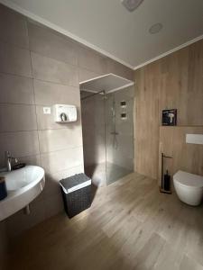 a bathroom with a shower and a sink and a toilet at Cidade Mar in Horta +19 photos