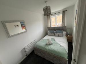 a small bedroom with a bed and a mirror at Cardiff Gate Lodge in Cardiff