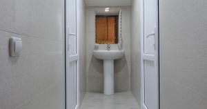 a white bathroom with a sink and a mirror at Lime Hotel & Restaurant Complex in Gyumri