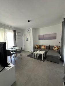 una sala de estar con un sofá y una mesa en Palm Complex Calma Di Mare Apartment, en Ofrinion