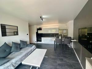 a living room with a couch and a kitchen at Royal Standing- Terrasse & Parking Privé in Évian-les-Bains