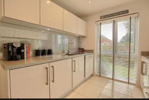 Una cocina con gabinetes blancos y una ventana grande. en 4 Bed modern luxury home, en Middlesbrough