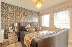 Un dormitorio con una cama grande y una lámpara de araña. en 4 Bed modern luxury home, en Middlesbrough