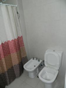 un bagno con un water e una tenda da doccia di Zen house Bs As a Buenos Aires