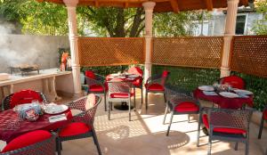 a patio with red tables and chairs on a patio at Villa Palma - With Free Parking in Mostar