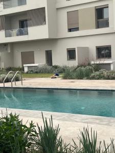 a swimming pool in front of a building at Studio calme à Zenata in Aïn Harrouda