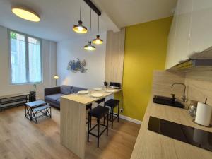 eine Küche und ein Wohnzimmer mit Sofa und Tisch in der Unterkunft Cour 36 in Ault