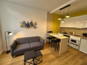 ein Wohnzimmer mit Sofa und eine Küche in der Unterkunft Cour 36 in Ault + 19 Fotos