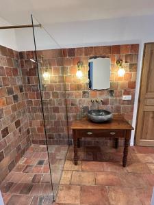 a bathroom with a sink and a tv on the wall at Casa Scaledda in Bocognano +19 photos